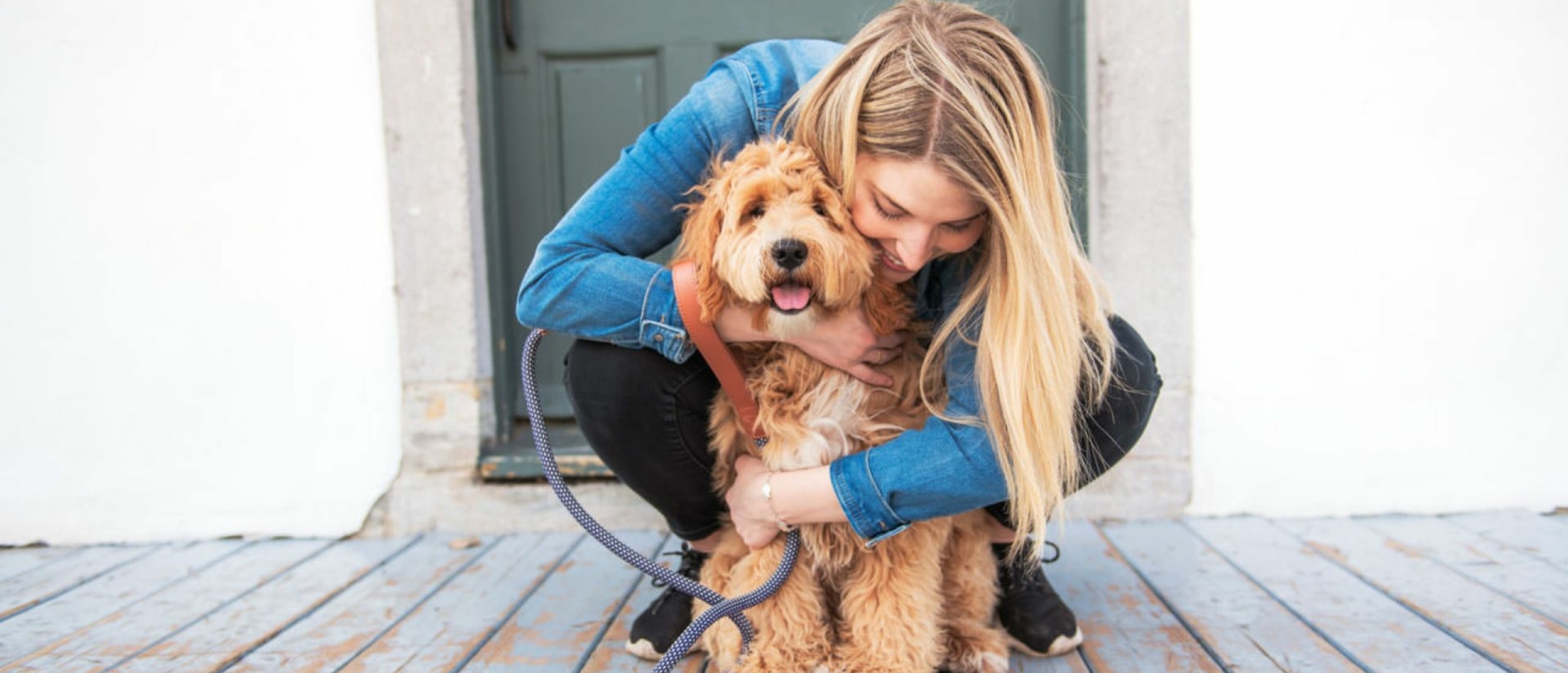 vrouw-knuffelt-met-blonde-labradoodle-pup